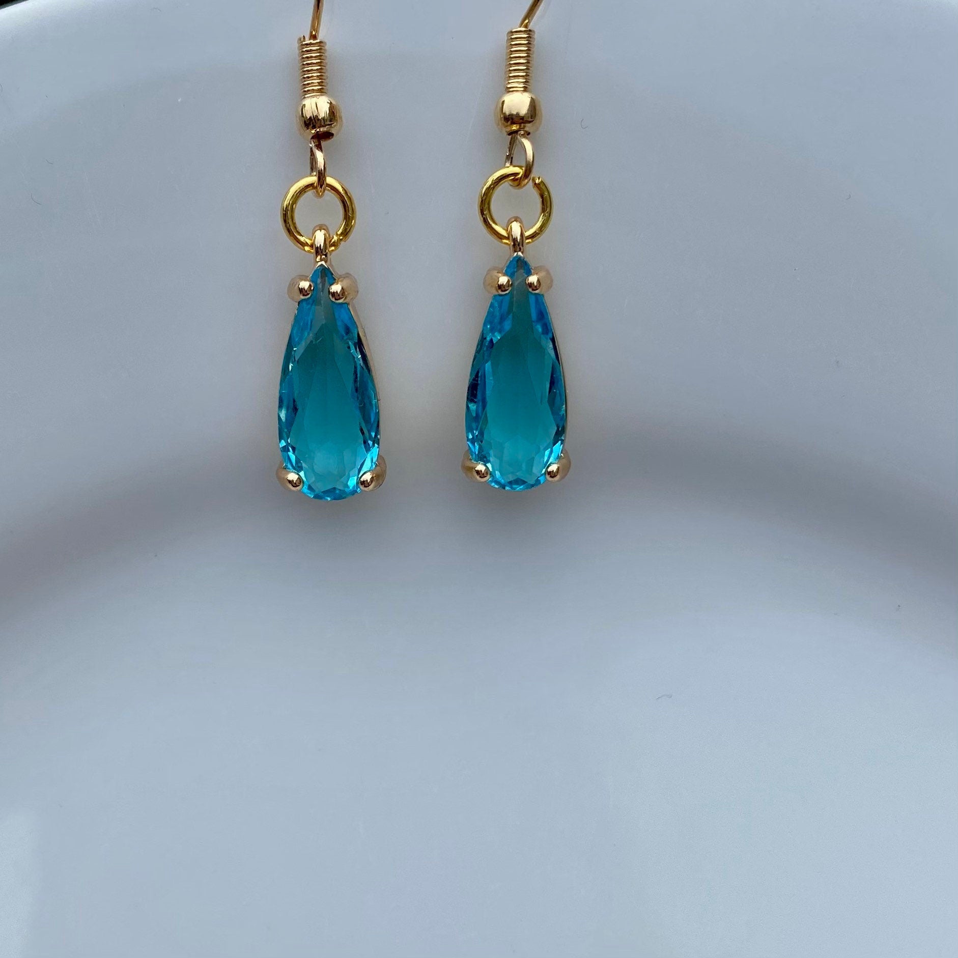 handmade clear blue  gemstone in claw setting gold birthstone earrings dangle